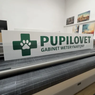 Szyld reklamowy UV na białym dibondzie z grafiką i tekstem