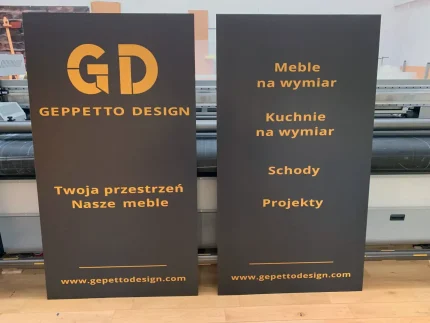 Dwie czarne tablice Geppetto Design z logo i listą usług: kuchnie, schody, projekty