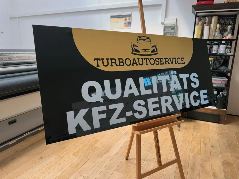 Duży szyld reklamowy z hasłem "Qualitäts KFZ-Service" nadrukowany na Dibondzie