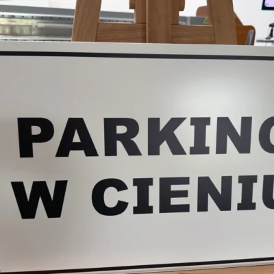 Druk UV na tablicy parkingowej z napisem „PARKING W CIENIU”, wyraźne litery na białym tle