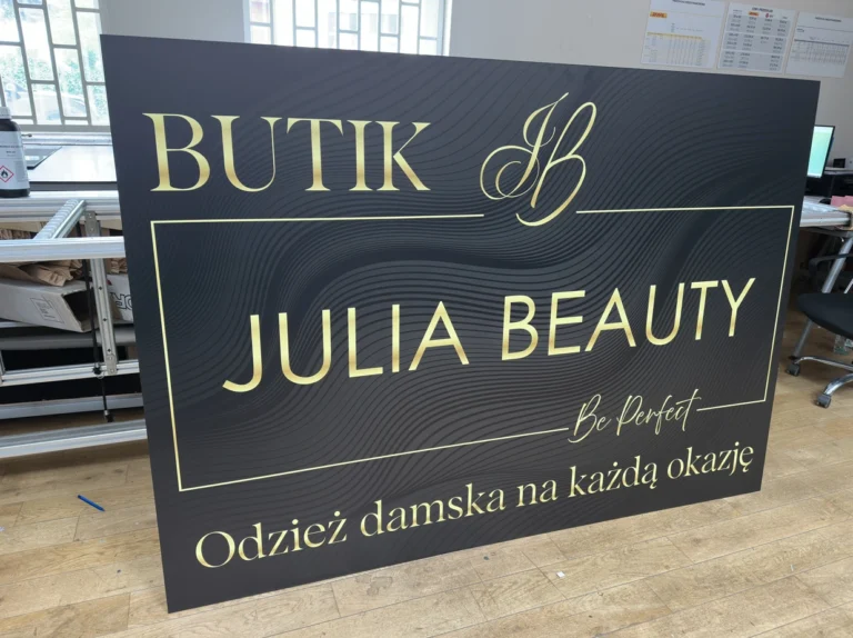 Tablica wykonana z czarnego Dibondu z eleganckim złotym nadrukiem UV, szyld dla butiku odzieżowego