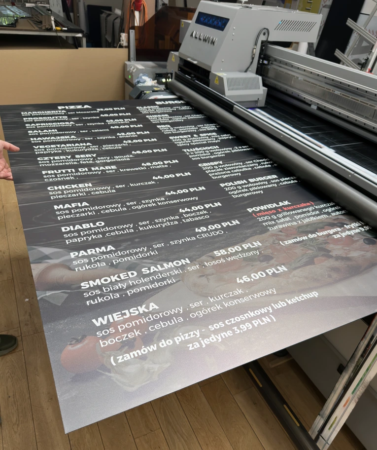 Moment produkcji tablicy menu restauracyjnego z użyciem druku UV na czarnym Dibondzie