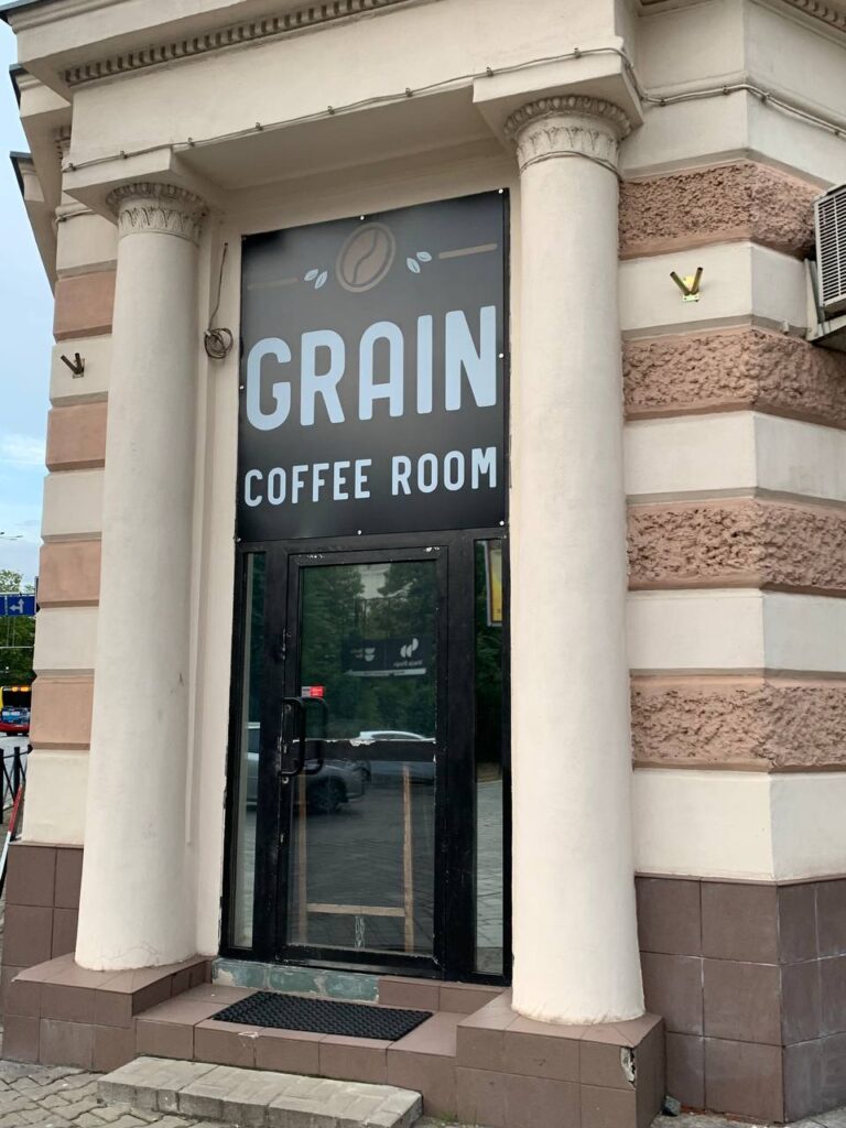 Frontowy szyld z logo GRAIN na płycie Dibond 3 mm z nadrukiem UV, fasada z kolumnami
