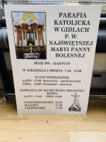 Biała tablica z grafiką kościoła i szczegółowym harmonogramem nabożeństw