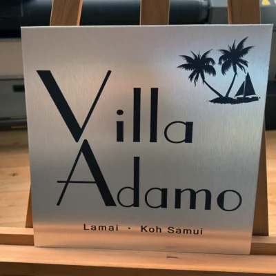 Tabliczka reklamowa z szczotkowanego srebrnego dibondu z napisem „Villa Adamo”