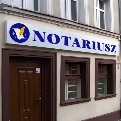 Kaseton reklamowy Notariusz z logo pióra i granatowym napisem na białym tle