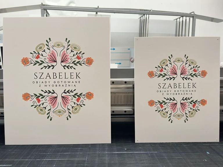 Dwie tablice Szabelek z motywem kwiatowym i napisem Obiady gotowane z wyobraźnią, tablice i szyldy reklamowe