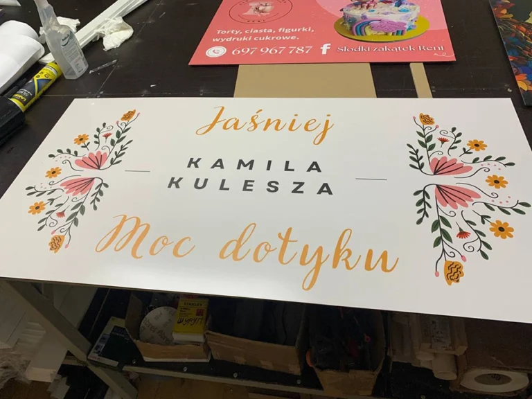 Tablice i szyldy reklamowe – elegancka tablica „Jaśniej – Kamila Kulesza, Moc dotyku”
