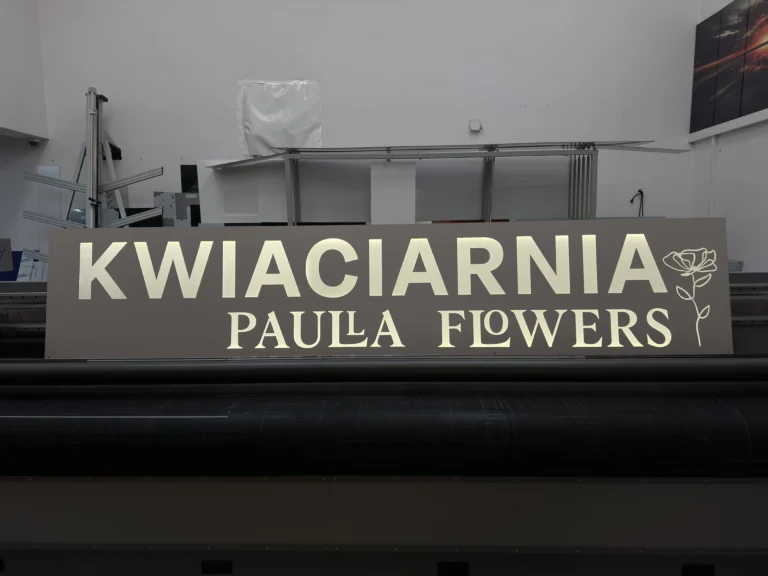 Panoramiczny szyld reklamowy z nadrukiem UV, duże litery i grafika na ciemnym tle