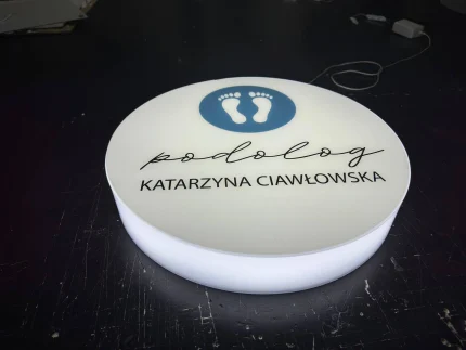 Podświetlany kaseton okrągły z plexi: podolog Katarzyna Ciawłowska, logo stóp, druk UV