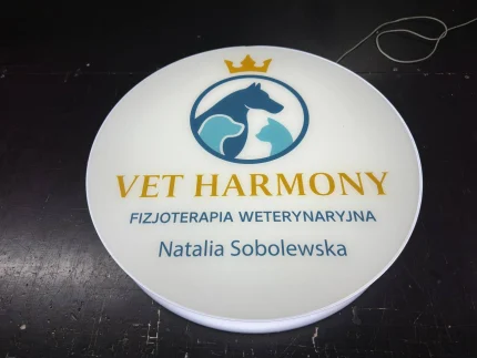 Okrągły kaseton z plexi z logo zwierząt VET HARMONY i nazwiskiem, szyld LED, druk UV