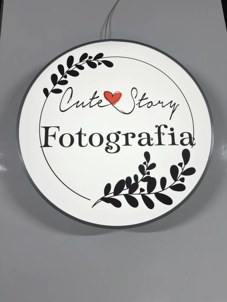 Okrągły kaseton reklamowy dla fotografa z czarnym logo