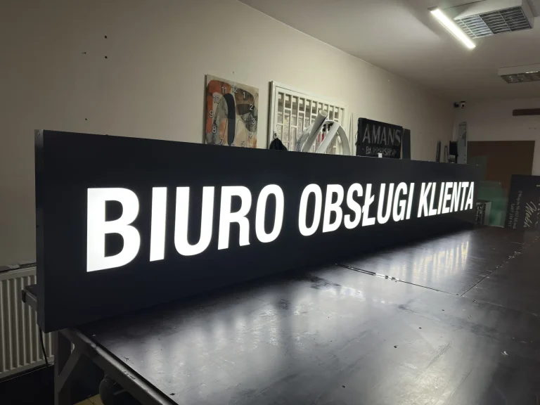 Czarny kaseton reklamowy z podświetlanymi literami