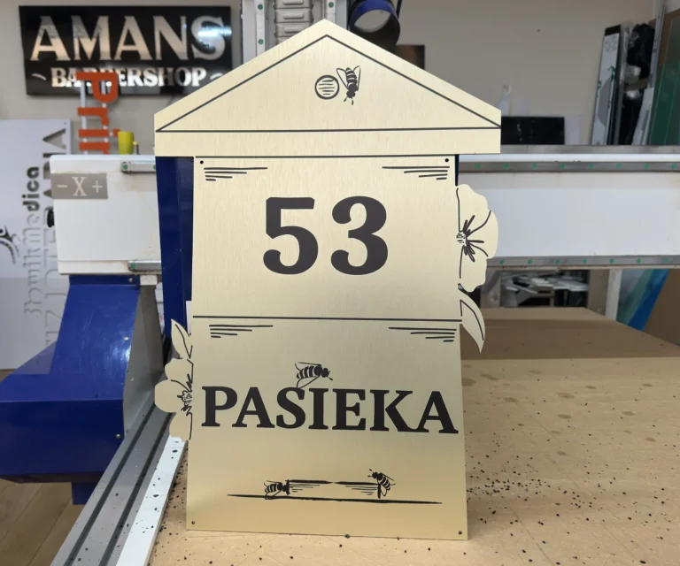 Tablica adresowa dla pasieki z numerem 53, motywem pszczół i czarnym nadrukiem na złotym tle