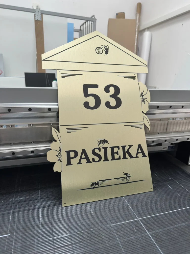 Złota tablica adresowa Pasieka 53 z grafiką pszczół, kwiatów i otworami montażowymi