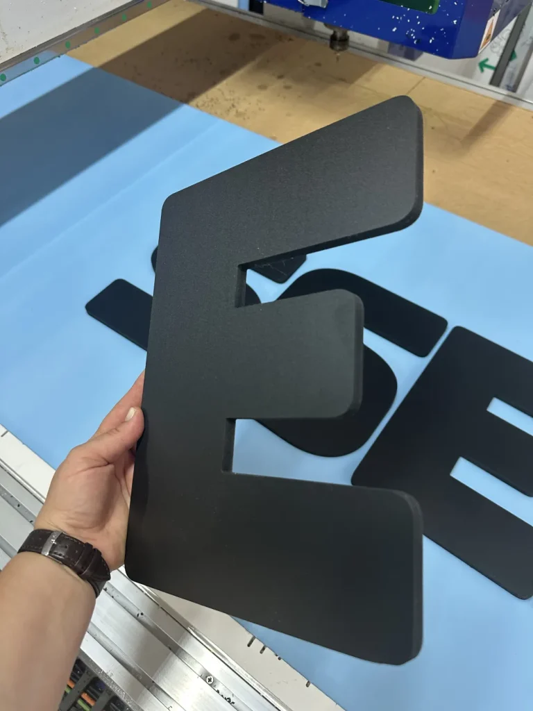 Czarna litera E 3D z PCV z widocznym profilem materiału