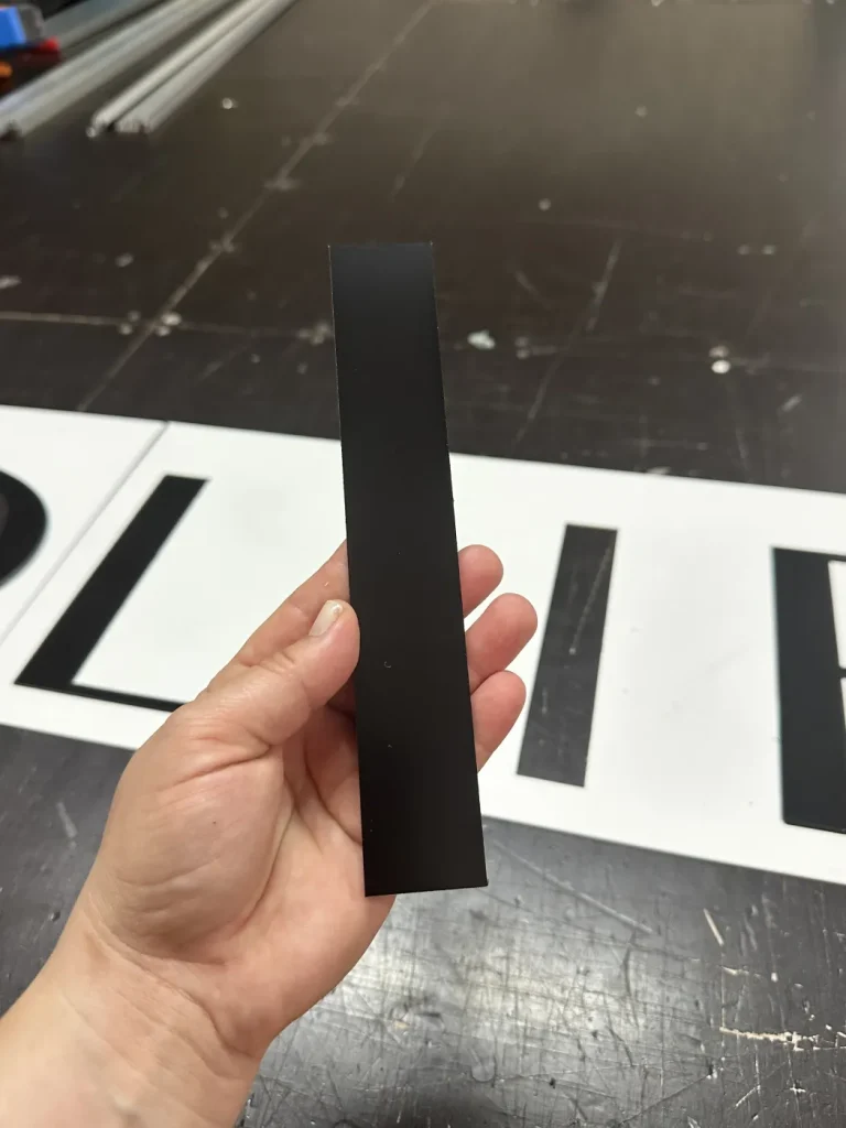 Czarna litera z dibondu pokazująca profil i grubość materiału