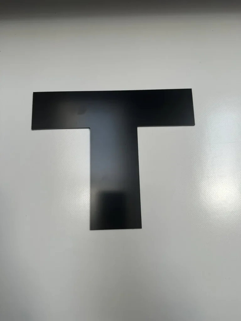 Czarna litera T z dibondu do nowoczesnych szyldów reklamowych