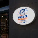 Owalny kaseton reklamowy na elewacji wypożyczalni rowerów