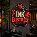 Czarny szyld Ink District z czerwonym LED i grafiką tatuażu